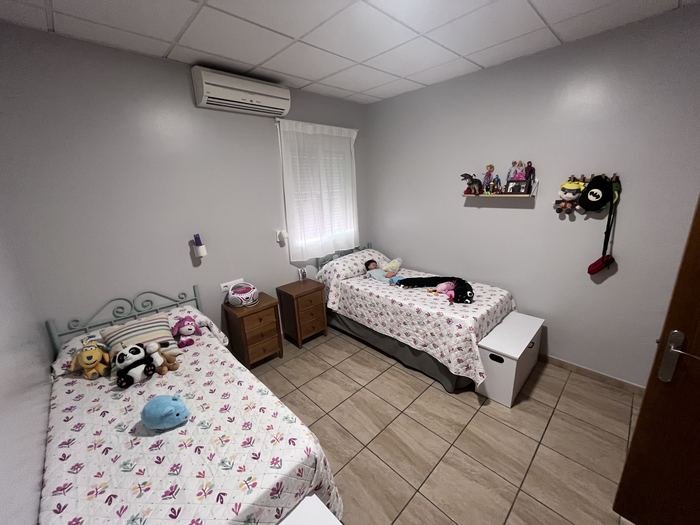 Habitación de la residencia con dos camas, mesillas y aire acondicionado